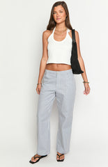 Model wears blue and white striped pants with a white top- brown belt- and matching handbag- showcasing stylish wide-leg trousers.