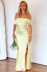blonde model wearing a yellow satin off shoulder formal gown with ruffle details at the split