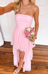girl wearing a baby pink tulle maxi dress with a high low skirt