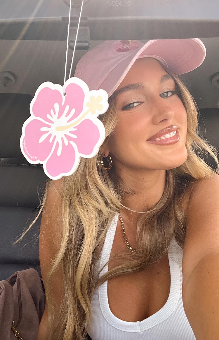 Girl in a car with a hanging pink flower air freshener