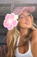 Girl in a car with a hanging pink flower air freshener