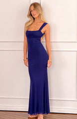 blonde model wearing a navy blue mesh formal maxi dress styles with gold bracelets and a gold flower necklace