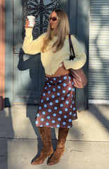 Fashionable woman wearing a cozy yellow cardigan and a brown polka dot midi skirt a perfect Fall outfit