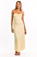 A model in a yellow lace maxi dress with a sweetheart neckline and thin straps. This gorgeous formal gown features a sheer lace fabric over a yellow lining. An amazing dress for prom or a wedding guest.