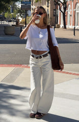 Model wearing a crisp white off-shoulder crop top and white wide-leg jeans perfect for a fresh Spring look