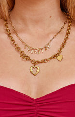 A chunky gold-toned necklace featuring a toggle clasp and an open heart pendant accompanied by a smaller solid heart charm.
