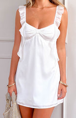 girl wearing a white satin homecoming dress with frill details paired with gold jewellery and a diamante handbag