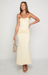 Blonde model wearing a strapless cream mesh maxi dress with ruched details through the bodice