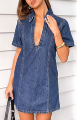 Model wears a dark wash strapless denim mini dress for a casual party.