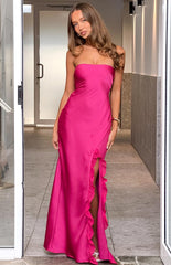 A long- strapless hot pink satin gown with a fitted bodice and a high leg slit adorned with ruffles. This elegant dress is suitable for a formal event- prom- or a gala.