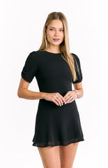 featuring a fitted waist that flows into a flared mini-skirt and ruched details on the sleeves.