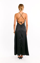The open back of a black maxi dress is shown on a girl. This formal dress highlights the halter neckline and adjustable ties across an open back. Perfect for a prom or special event.