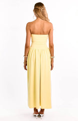 The back of a yellow strapless evening dress is shown on a girl. This sleek formal gown has a simple back design and a fit and flare silhouette. Perfect for a graduation or black tie event.