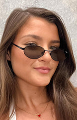 brunette model wearing black metal framed sunglasses with slim metal arms