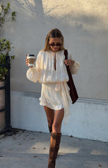 Model in a beautiful pearl satin mini dress with long bishop sleeves a romantic look for a special occasion or date night