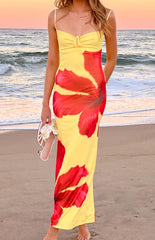 A yellow maxi dress adorned with prominent red hibiscus floral prints- designed with thin spaghetti straps and a flattering ruched tie-front bust- suitable for resort wear.