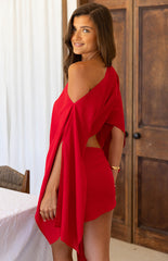 Close up of a girl wearing a red mini dress with an asymmetric sleeve and wrap detail at te skirt. The perfect choice for a christmas celebration or party!