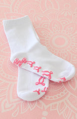 white yoga socks with pink bow shaped grips on the bottom and a graphic 'beginning boutique' grip