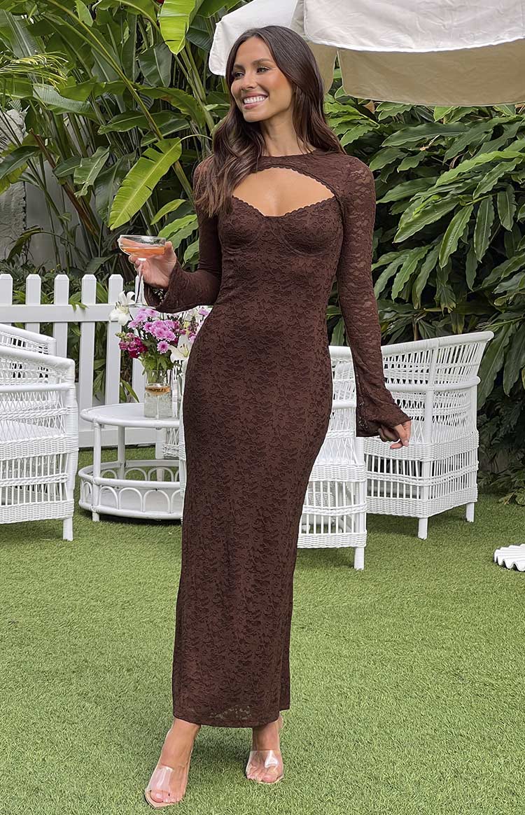 Brunette model wearing brown lace maxi dress holding a drink outdoors.