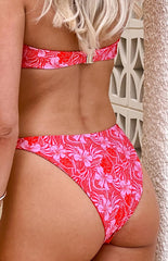 model wearing red bikini bottoms with a pink floral pattern