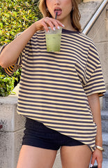 Model wears an oversized yellow and white stripe tee perfect for casual weekend outfits.