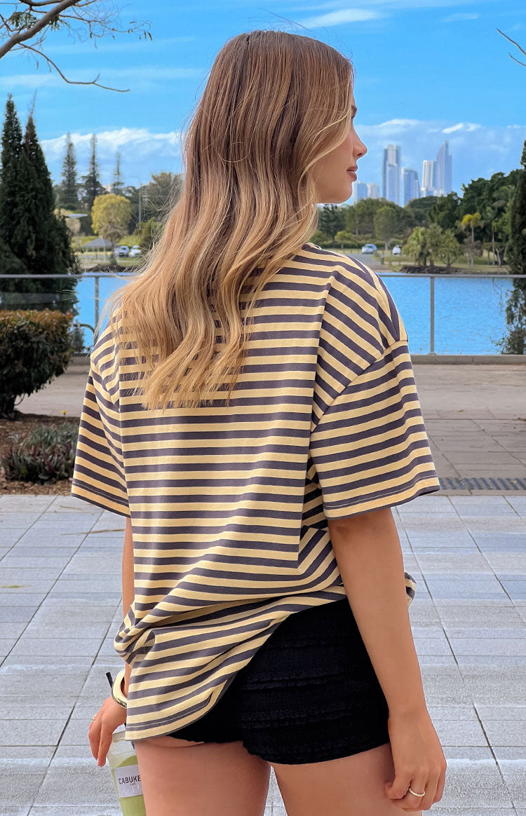 Girl wearing a casual yellow striped oversized t-shirt for a relaxed street style look.