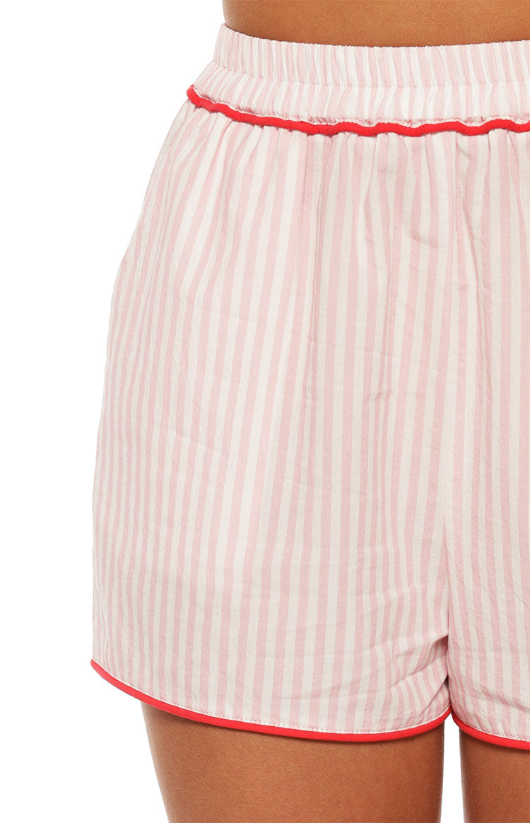 Model wears the Alexea Pink Stripe Pajama shorts featuring red contrast piping details. These shorts perfect for a comfortable and sweet summer sleepwear set.