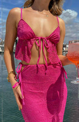Pink lace crop top with open front and tie on model with drink in hand.