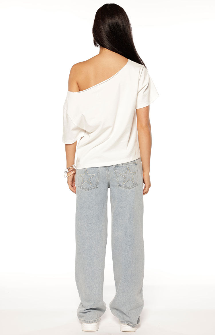 Stylish woman in a white off-shoulder 08 crop top and baggy jeans for a casual Spring brunch outfit