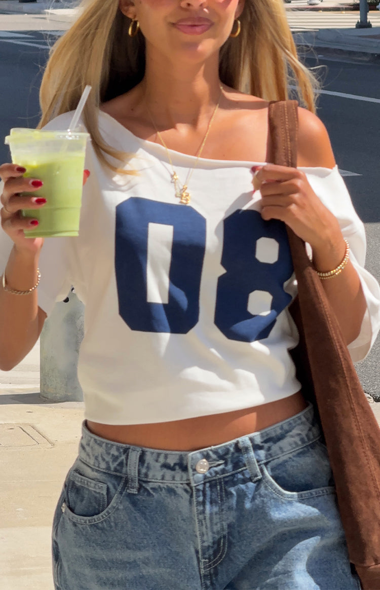 Stylish woman in a white off-shoulder 08 crop top and baggy jeans for a casual Spring brunch outfit