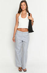 Model wears blue and white striped pants with a white top- brown belt- and matching handbag- showcasing stylish wide-leg trousers.