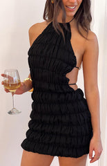 A model wearing a black halter neck mini party dress with bubble ruche detailing and an open tie back