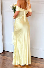 girl wearing a light yellow off shoulder satin maxi dress with an adjustable tie back detail