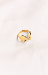 An open-ended gold-toned ring featuring a scallop shell on one end and a textured starfish on the other.