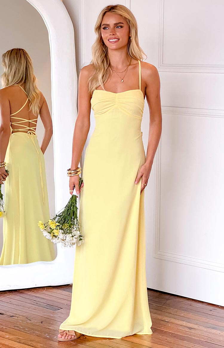 blonde model wearing a yellow maxi dress with ruched bust details and a sweetheart neckline