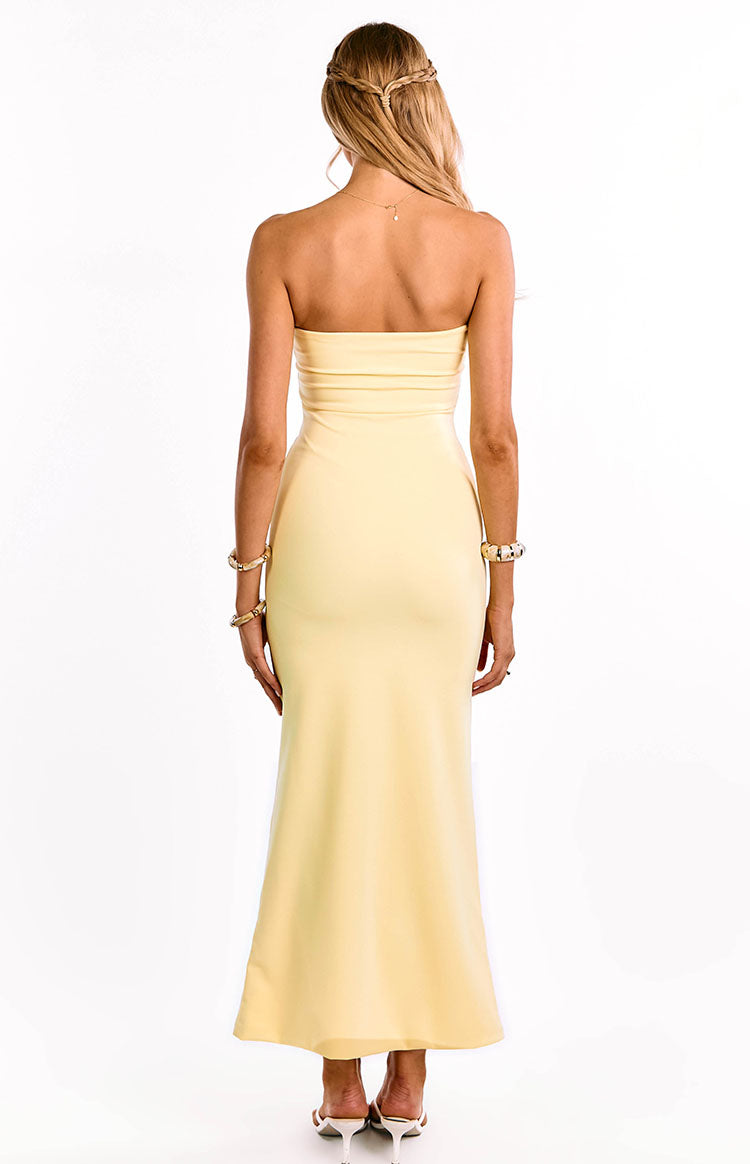 he back of a yellow strapless maxi dress is shown on a girl. This beautiful formal dress highlights the simple back design and the fitted silhouette. Perfect for a prom or formal.