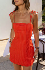 Girl wearing the Beau Red Stripe Mini Dress showing the adjustable tie strap detail a flattering and playful choice for a casual event.