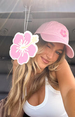 Pink hibiscus flower air freshener hanging in a car