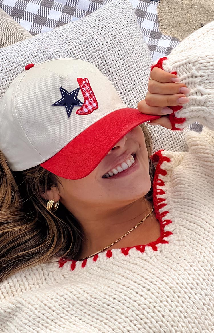 Model wearing a red and cream contrast dad cap with a red gingham cowboy boot and navy star design