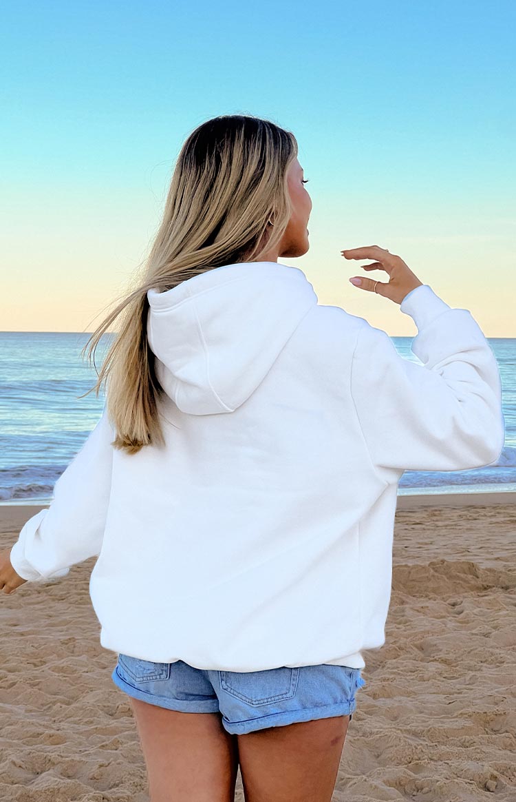 The back view of a plain white hooded sweatshirt with a relaxed fit and ribbed cuffs and hem.
