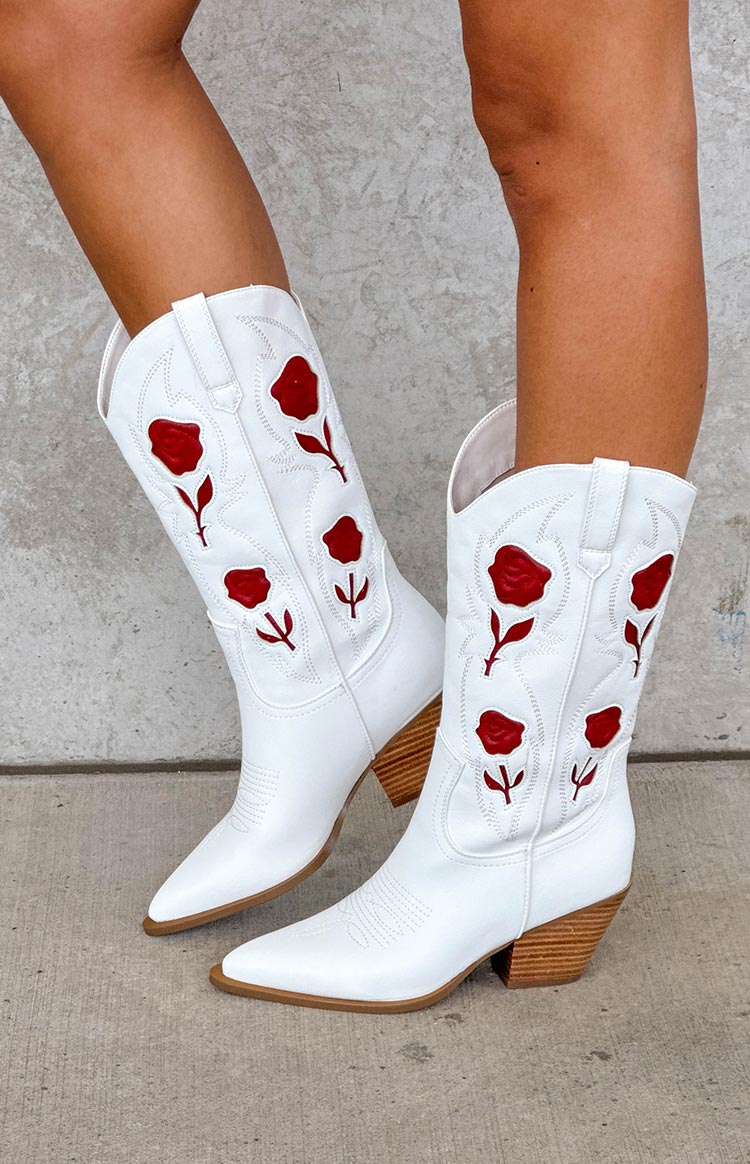 model wearing white faux leather cowboy boots with floral details