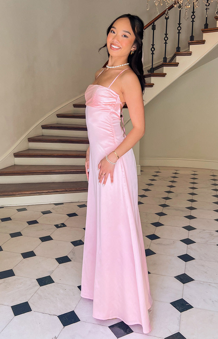 Pink satin maxi formal dress with open tie up back design on dark haired model.