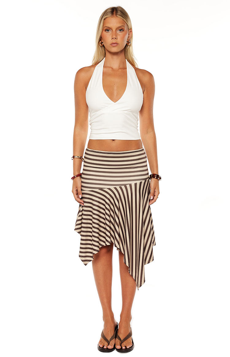 Model styles the Brighton Brown Stripe Asymmetrical Midi Skirt with a white top. This mid rise striped skirt is perfect for a casual weekend brunch or a daytime date.