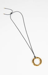 A simple gold pendant necklace with a circular charm on an adjustable black cord a chic accessory for any outfit