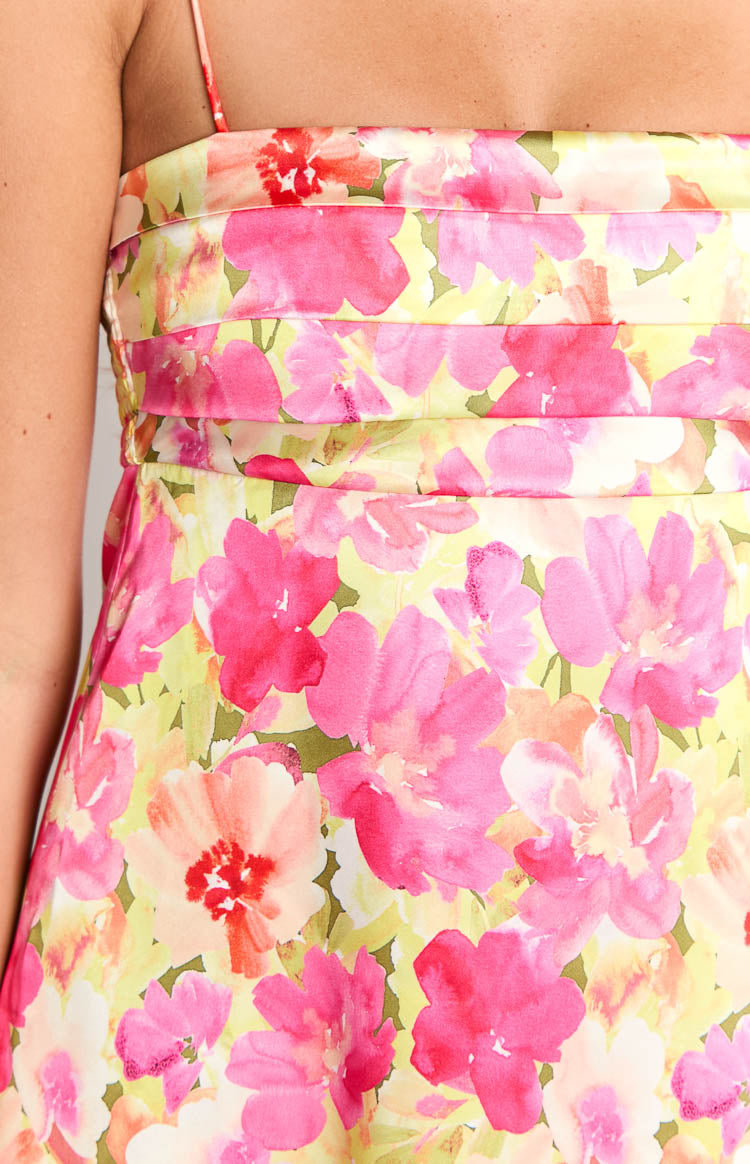 Fashion model showcasing a beautiful pink and yellow floral print mini slip dress- featuring delicate spaghetti straps and a flowing A-line silhouette- ideal for warm weather.