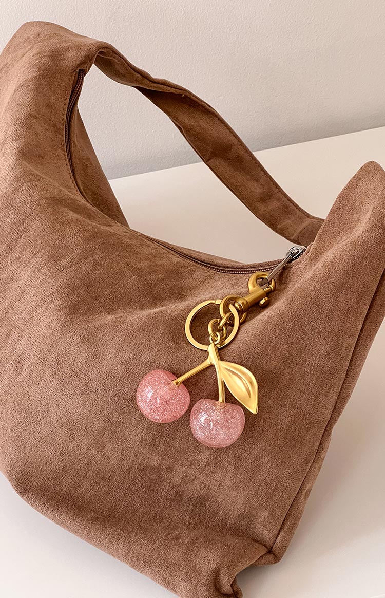 Faux suede brown shoulder bag with a pink glitter cherry keyring with gold details and hardware