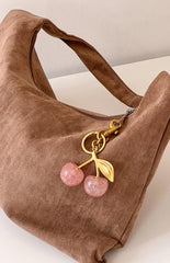 Faux suede brown shoulder bag with a pink glitter cherry keyring with gold details and hardware