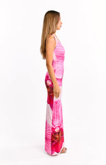 Our model wearing a light pink halter-style maxi dress with a large vibrant pink floral print. The dress has a plunging V-neckline and a subtle ruching detail.