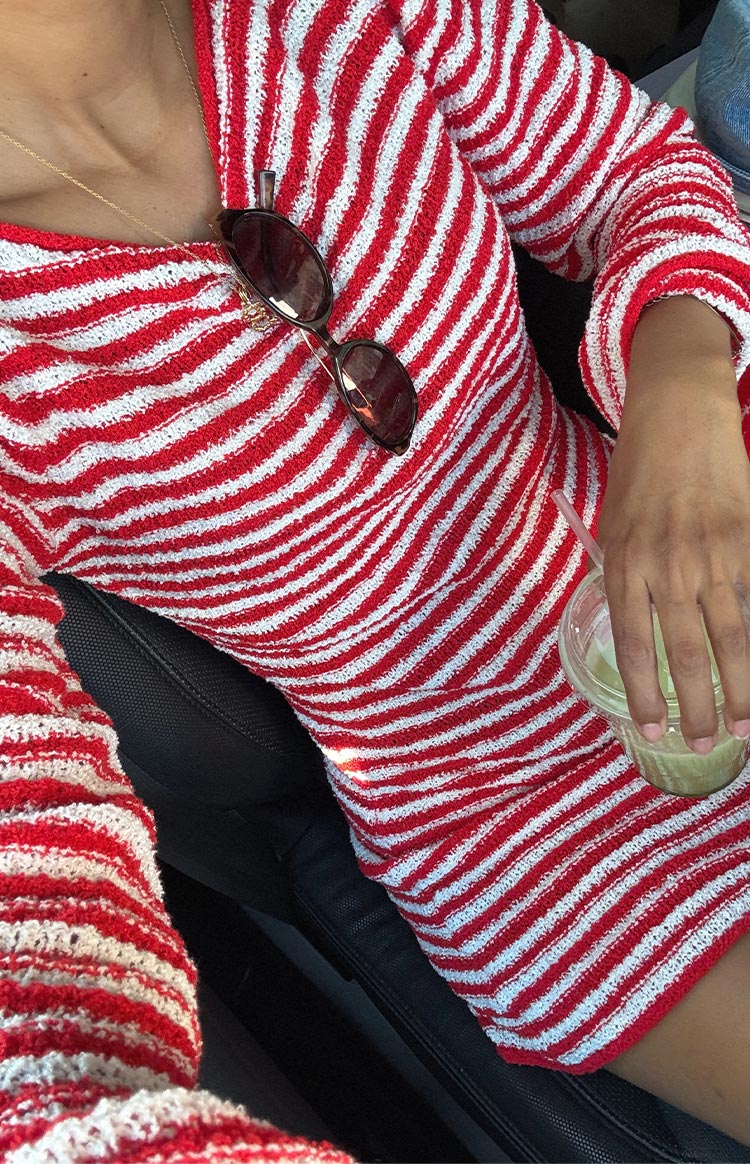 Close-up of a red and white horizontal striped long-sleeve knit mini dress with a boat neckline.