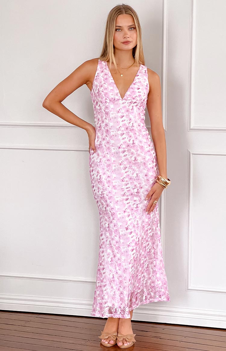 Pink lace floral maxi dress on brunette model holding a pink drink.